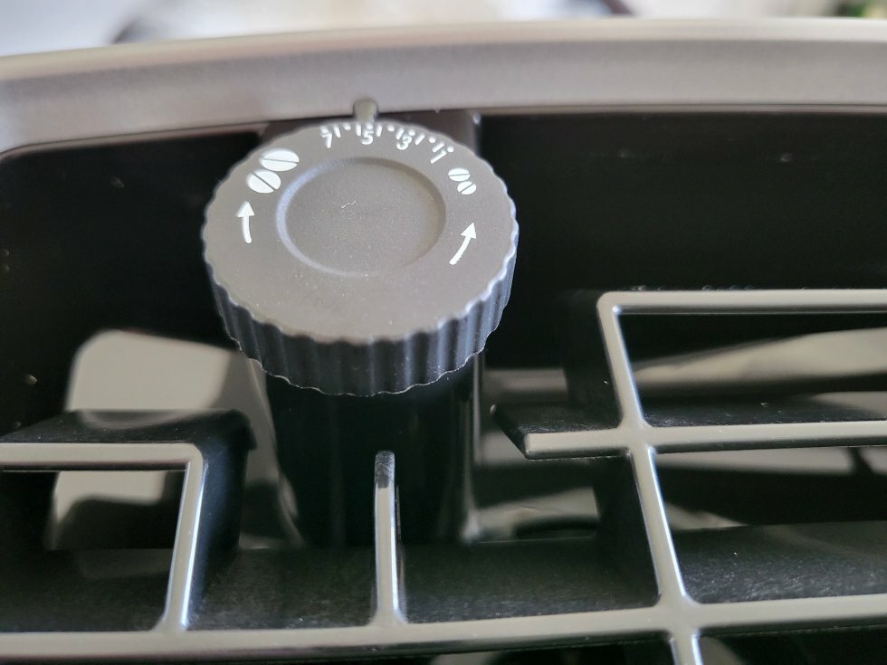 Kaffekværnen er let at indstille med en fingerbetjent skrue der stikker over selve bønnebeholderen - Test: De'Longhi Magnifica S Smart ECAM250 - En fuldautomatisk kaffemaskine på budget